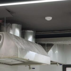 Fire safety detector on the ceiling in the kitchen near the hood. Smooth camera movement. High quality 4k footage