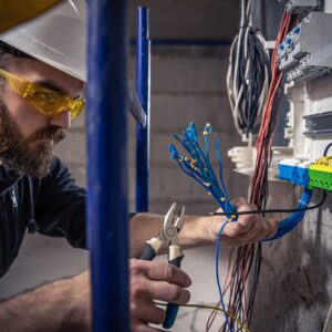 male-electrician-works-switchboard-with-electrical-connecting-cable (1)